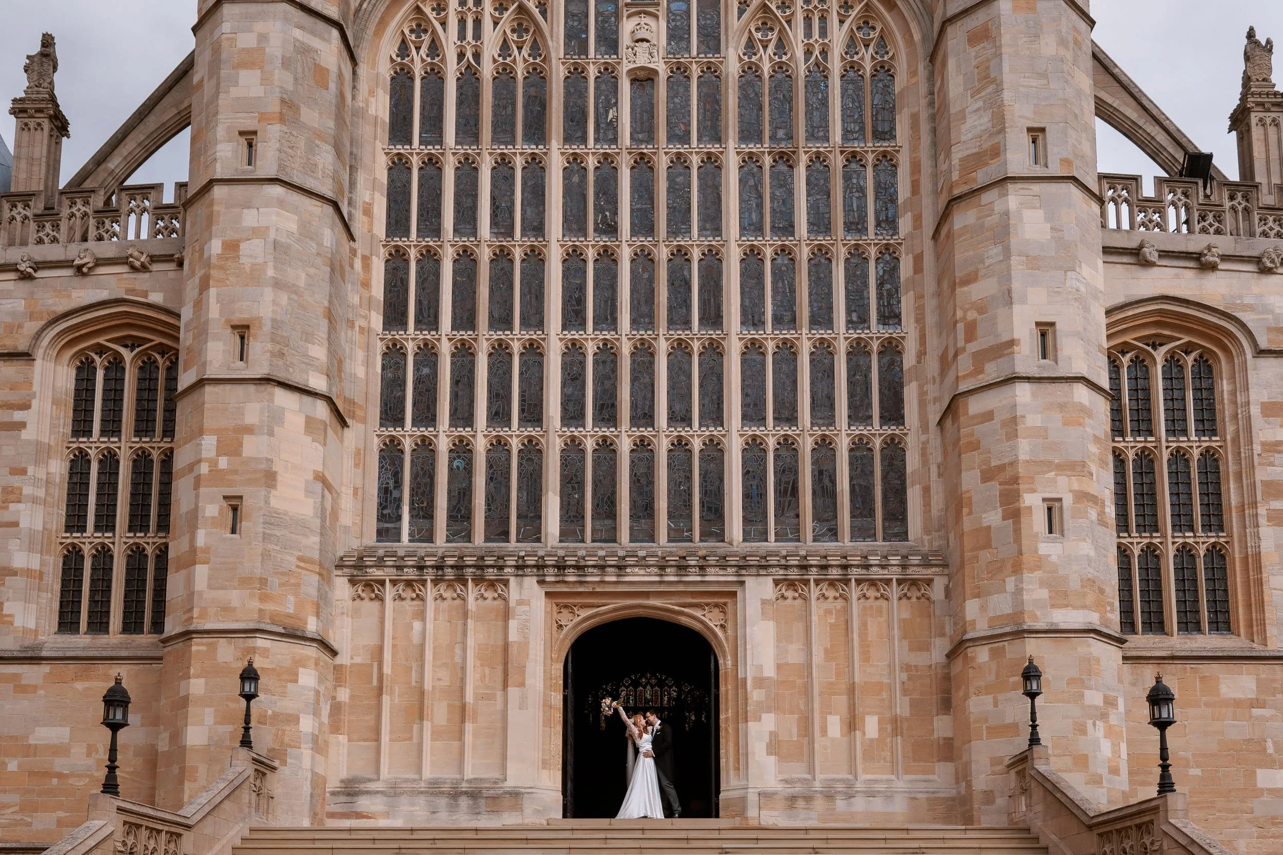 Clemmie & James celebrate on the West Steps of St George's Chapel following their wedding.
