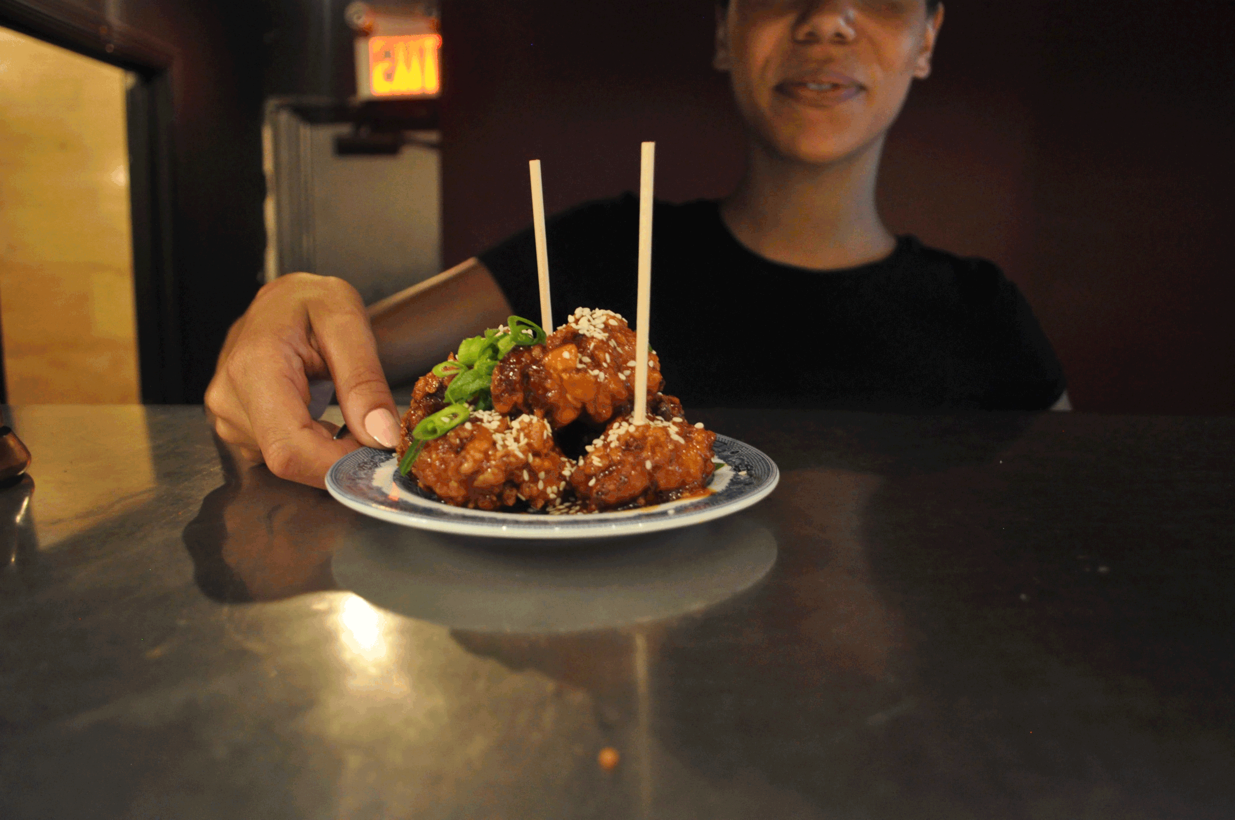 server holding plate of korean fried chicken