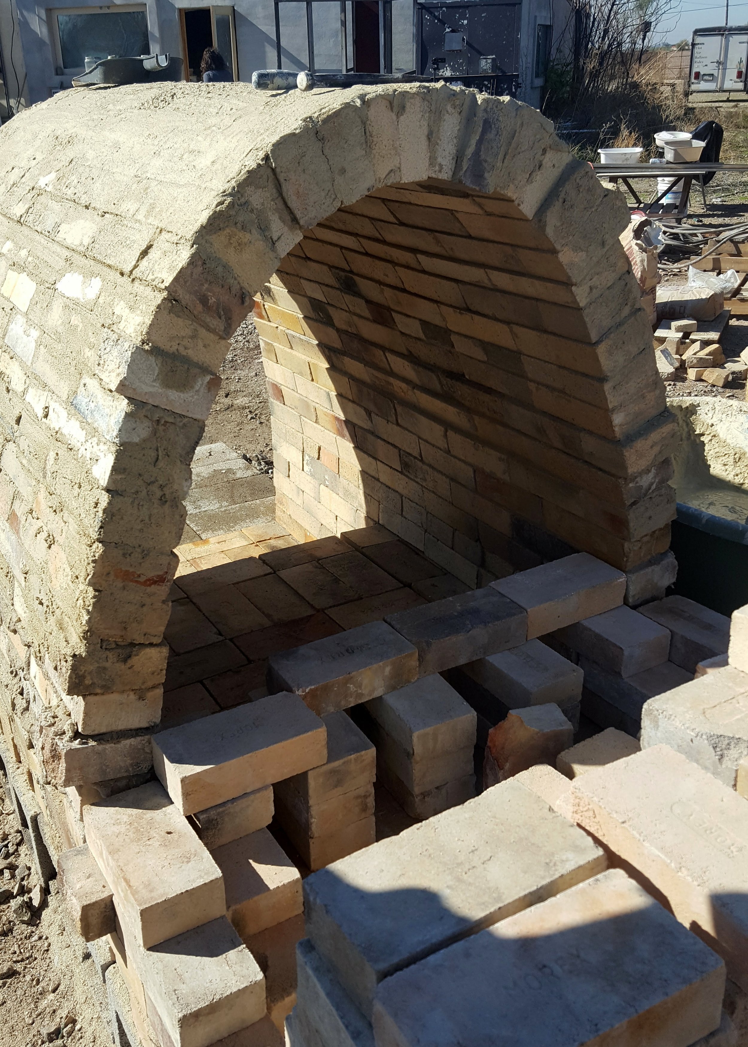 The completed arch from the back, and starting on the chimney. The chimney, along with little slots at the back of the arch, will help to suck through the air from the front of the kiln out the back. The arched shape will help the heat and flames circulate evenly through the kiln.