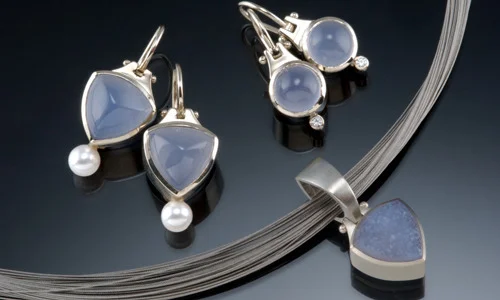   Clockwise left to right: 
 E97 14K white gold 11mm trillion drop earrings with chalcedony and pearls 
 E114 14K white gold 8mm round drop earrings with chalcedony and .06cttw diamonds 
 N182 14K white gold reversible large trillion nature carved