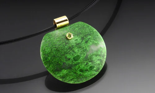   Free form stone pendant in 18K yellow gold. Maw-sit-sit with 2mm faceted demantoid garnet accent. Width 1.25" Length 1.25" Depth 0.25"     