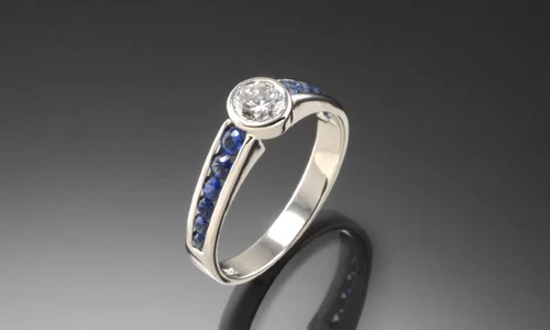   Engagement ring in 18K white gold, blue sapphires and center diamond. Width approximately 0.15"    