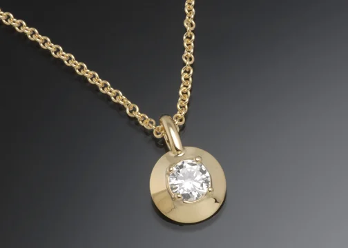   18K yellow gold pendant with 6mm diamond. Diameter 0.4" 
 &nbsp; 
 Shown on 14K yellow gold cable chain.  