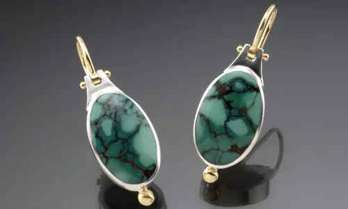  Oval hinge earrings in chinese turquoise, sterling silver and 18K accent and earwire. Earrings snap shut securely at the back. Length 1.25" Width 0.5" Depth 0.25" ﻿  