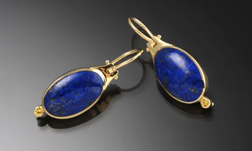  Oval hinge earrings in lapis and 18K yellow gold. 2mm yellow sapphire accents. Earrings snap shut securely at the back. Length 1.25" Width 0.5" Depth 0.25"&nbsp;&nbsp; ﻿  