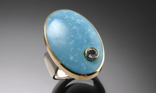   Inlay ring in 18K yellow gold, sterling silver, turquoise and 4.5mm faceted aquamarine. Height 1.25" Width 1" Shank width 0.2" - 0.4" ﻿  