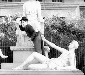 Charlie - a street person - wakes up on a neoclassical statue in City Lights Charlie Chaplin 1931