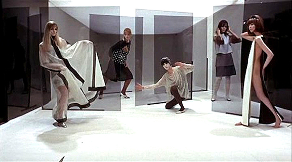 Blow-Up Models pose for Thomas. The artificiality is emphasized with the plastic panels while the space itself forms a box that parodies the camera.