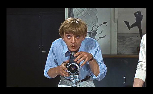 Blow-Up Thomas shooting - note the John Cowan prints in the background - on the left a woman floating through the air and on the right a man about to plunge into the sea - and the photographer as master of the elements - but is he?
