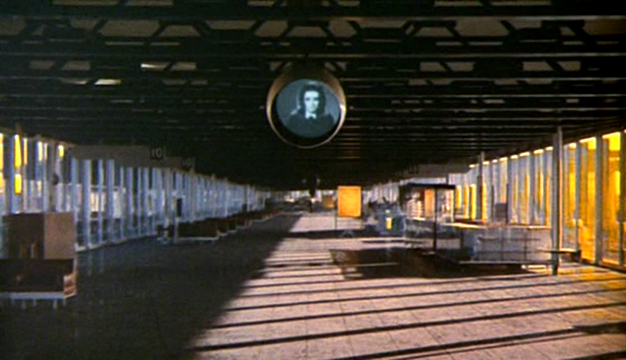 Toby Dammit The strangely depopulated airport is both hyper-real and fake, ominous and banal. We might assume it is a painting but for the fact that the camera tracks forward into the space, eventually tilting upwards towards the black and white video screen - an image that seems to come from some other time-frame or reality. The sort of space that would later be referred to as a "non-place" by sociologists like Marc Augé.