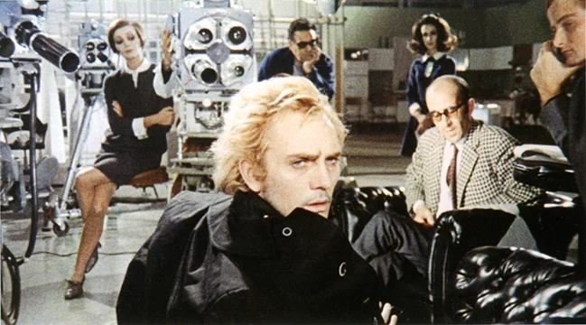 Toby Dammit Toby in the film studio - the busy image is a typical Fellini tableau - the zoom lens on the television camera on the left (a comical phallic prop) is counterbalanced by the crew on set all in their own worlds while Toby's attention is elsewhere off screen.