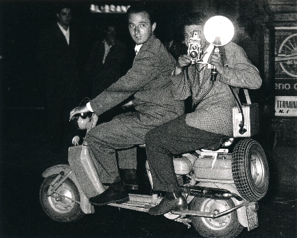 Unknown Photographer, Tazzio Secchiaroli. Secchiaroli is at the throttle of a Lambretta with Luciano Mellace behind him with a Rolleicord camera with flash. 1952