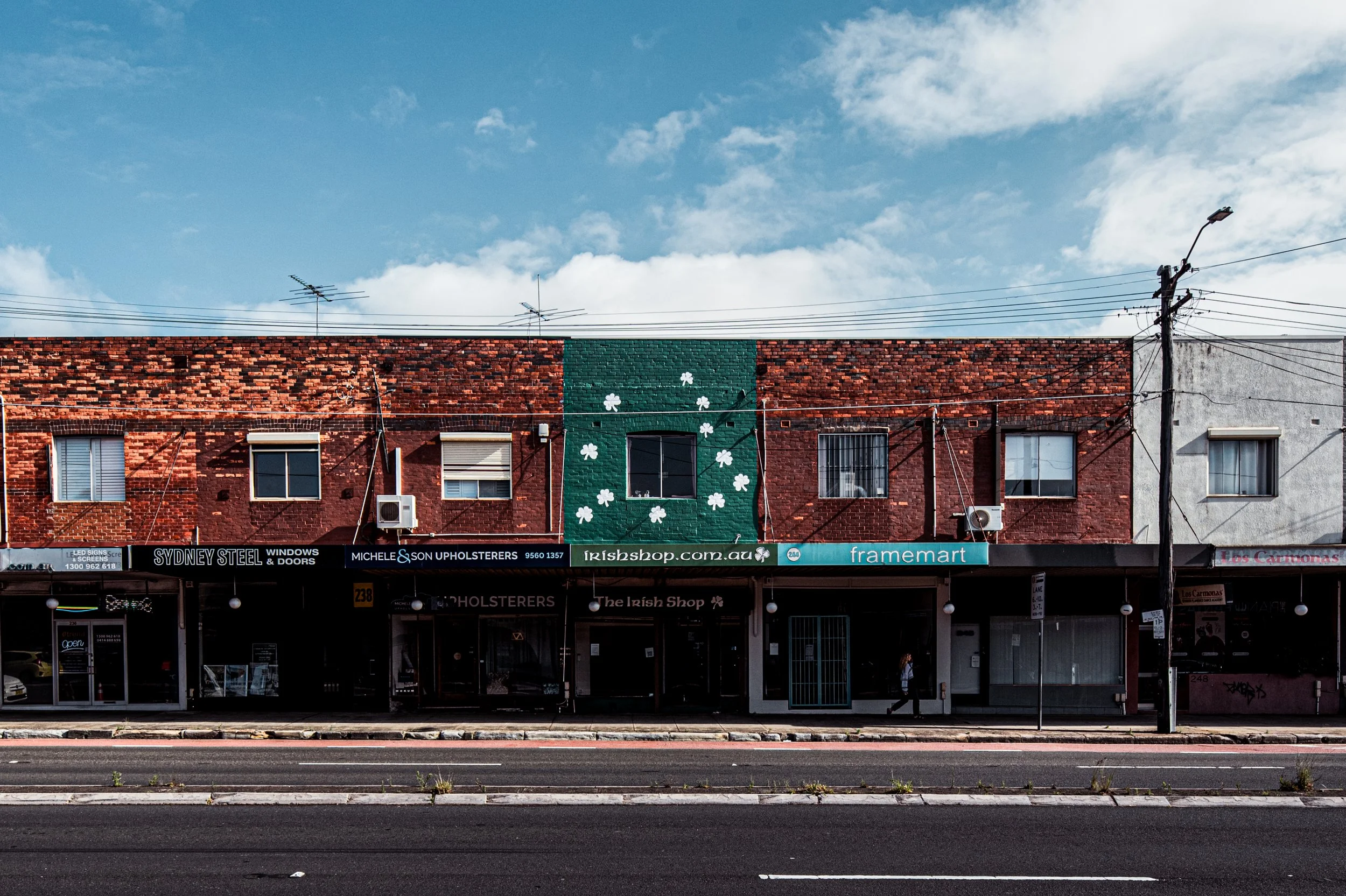    This Place, Before   looks at Parramatta Road at a moment of change. Once a major commercial spine, much of the road now sits in decline, yet its buildings still hold the layers of history that shaped it. Through direct, façade-focused photographs