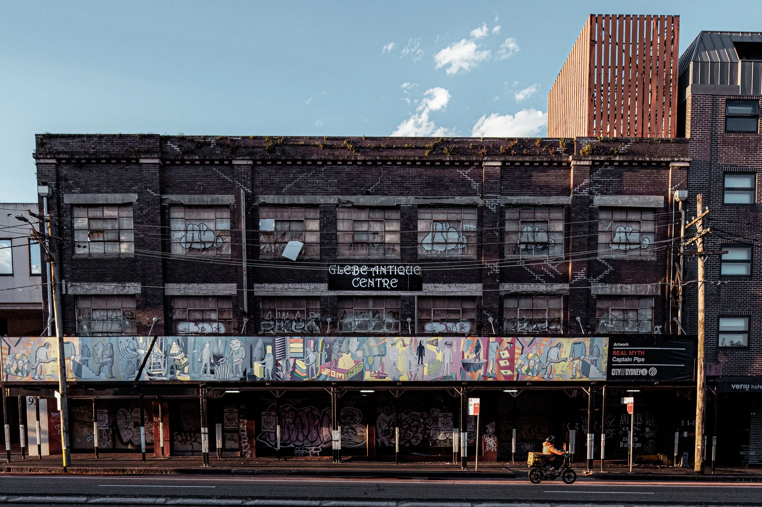  92 Parramatta Road, Camperdown  A 1920s-30s industrial warehouse with dark brickwork and steel-framed factory windows typical of the interwar industrial belt through Camperdown and Annandale. Before becoming the Glebe Antique Centre, it likely house