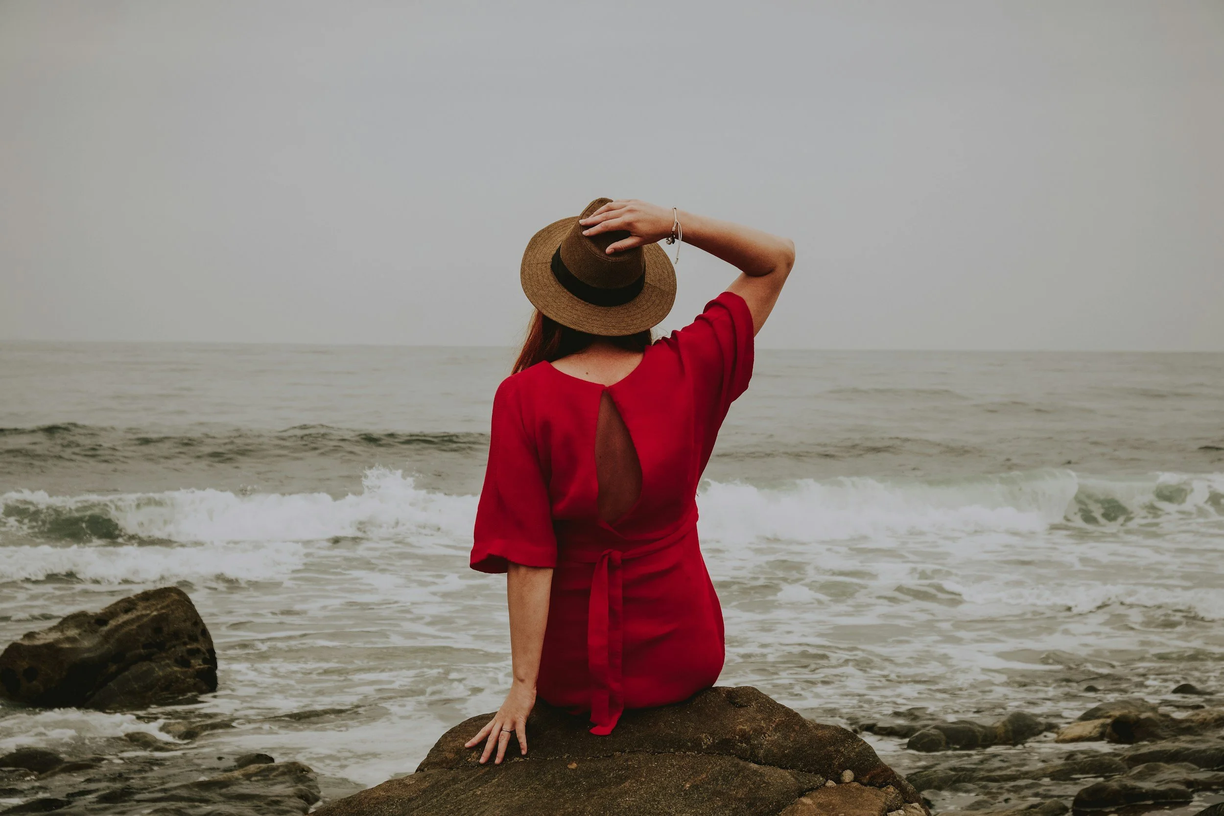 woman sitting by ocean