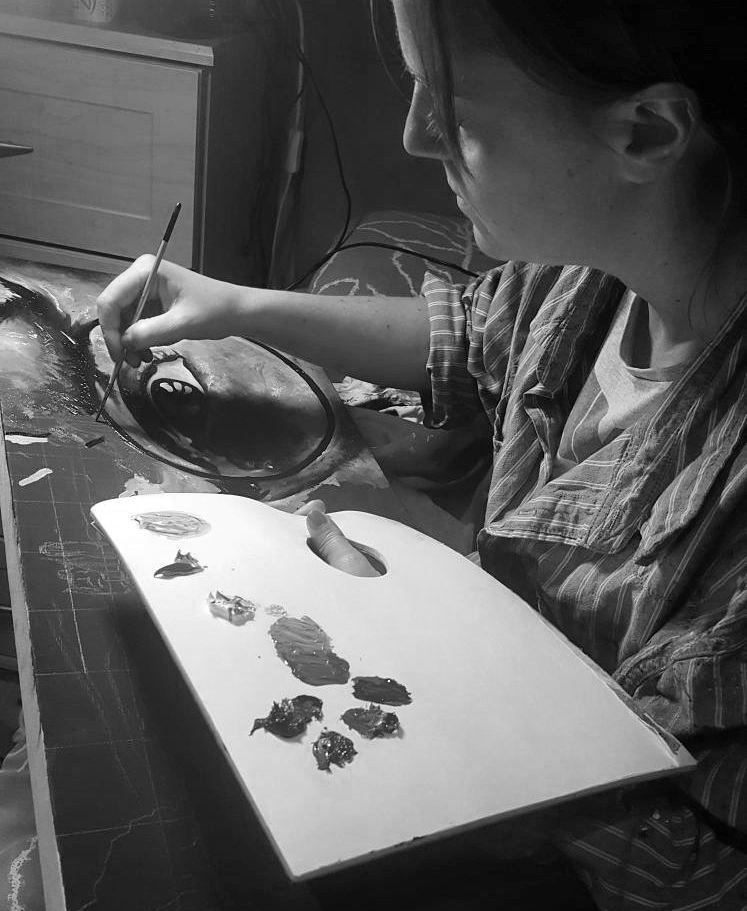 Artist Emma Worth painting in her home