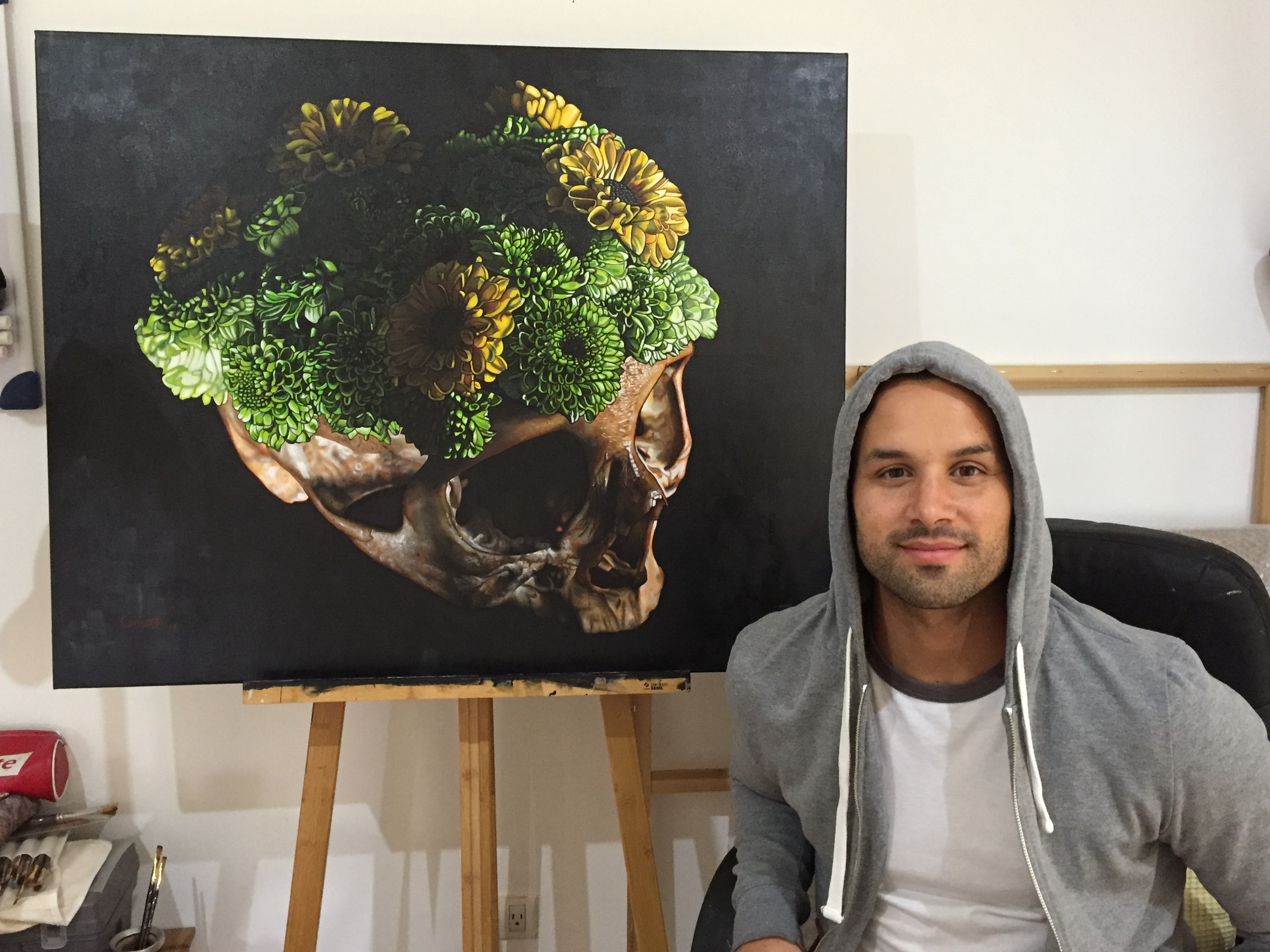 Artist Chrispapita Escobar in his studio in Guatemala with his painting, "Vanitas Nebula"
