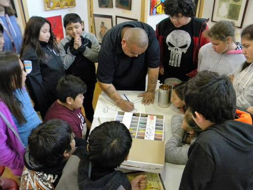 Pepion in his community teaching children the methods behind his art.
