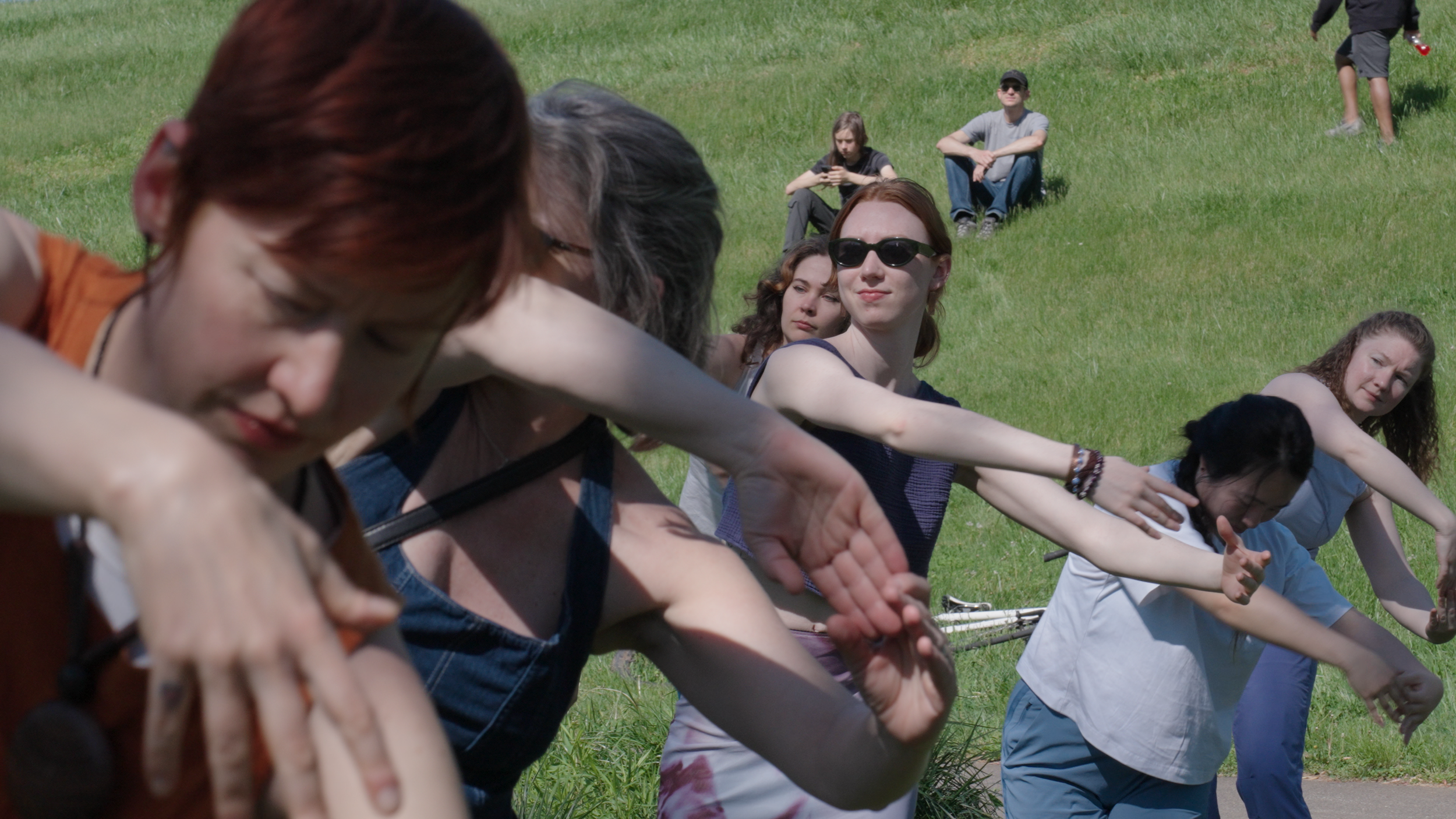 A close up of several people dancing together, swaying to one side.