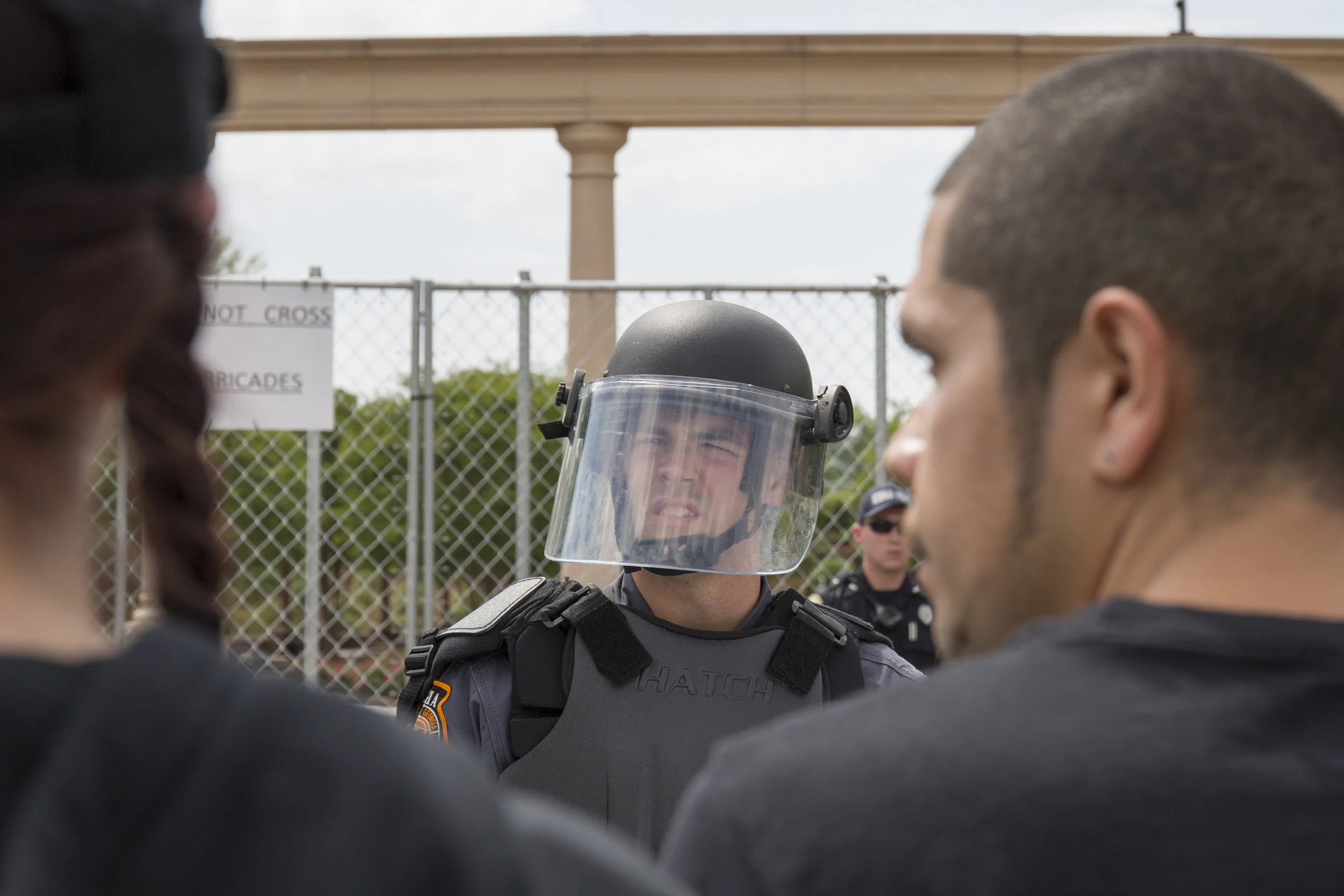 A guard in full riot gear holds a barricade separating protestors from a group of Neo-Nazis at gathering in Newnan, GA.