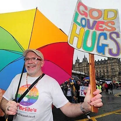  Open Table Liverpool community co-facilitator Kieran Bohan eading our church group in the Liverpool Pride march, with one of a series of affirming and apologetic messages. PHOTO: Liverpool Echo 