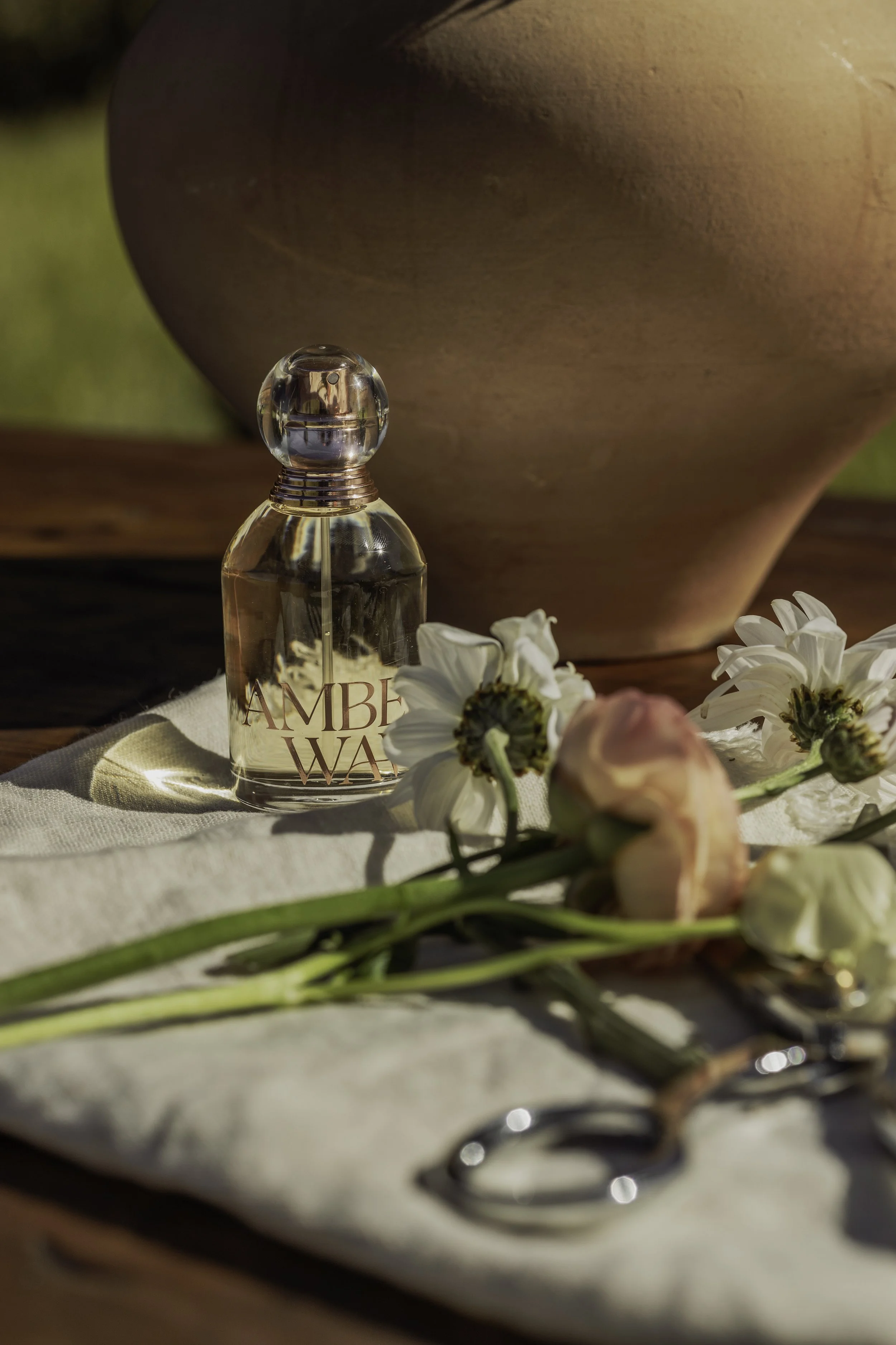 Tru Western Amber Waves perfume bottle styled on soft neutral linen in warm natural light.