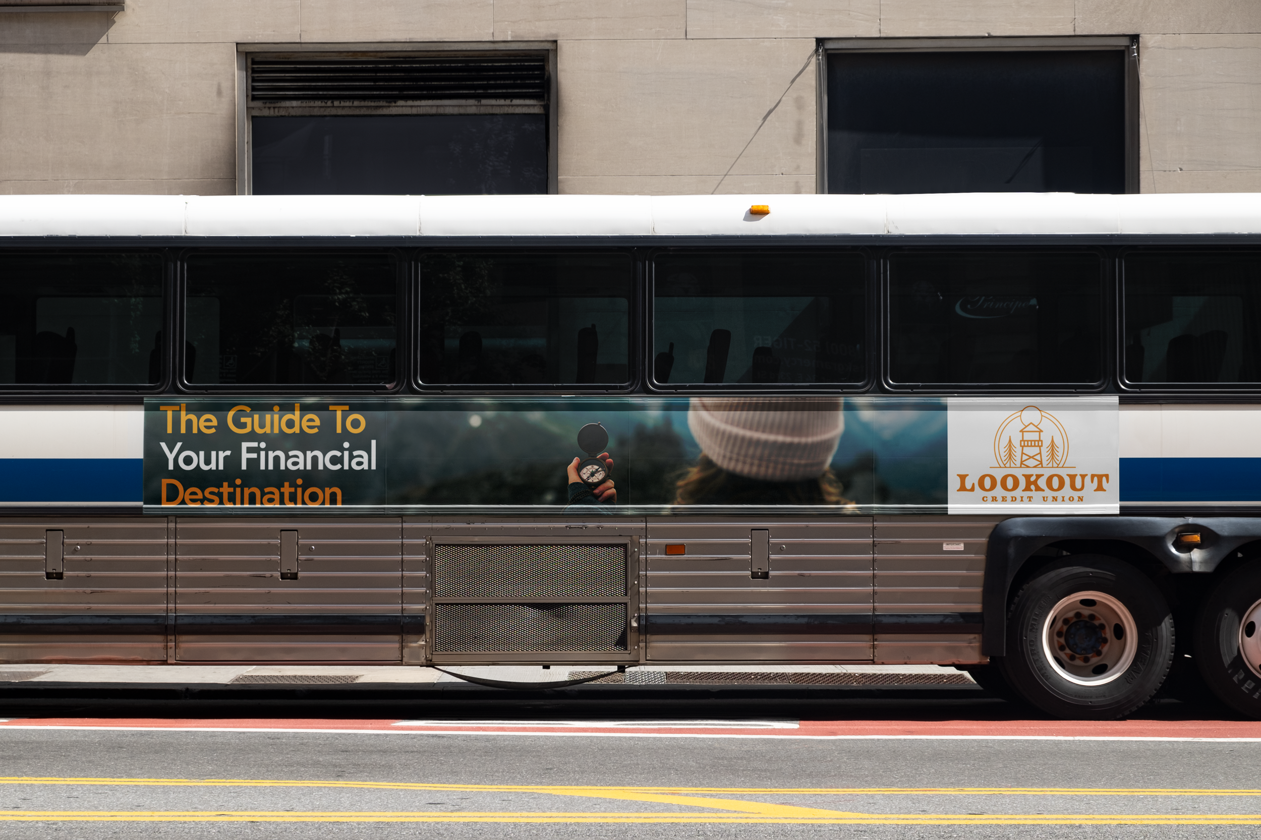 A city bus with an advertisement for Lookout Credit Union promoting financial guidance, featuring a person holding a compass and looking into the distance.