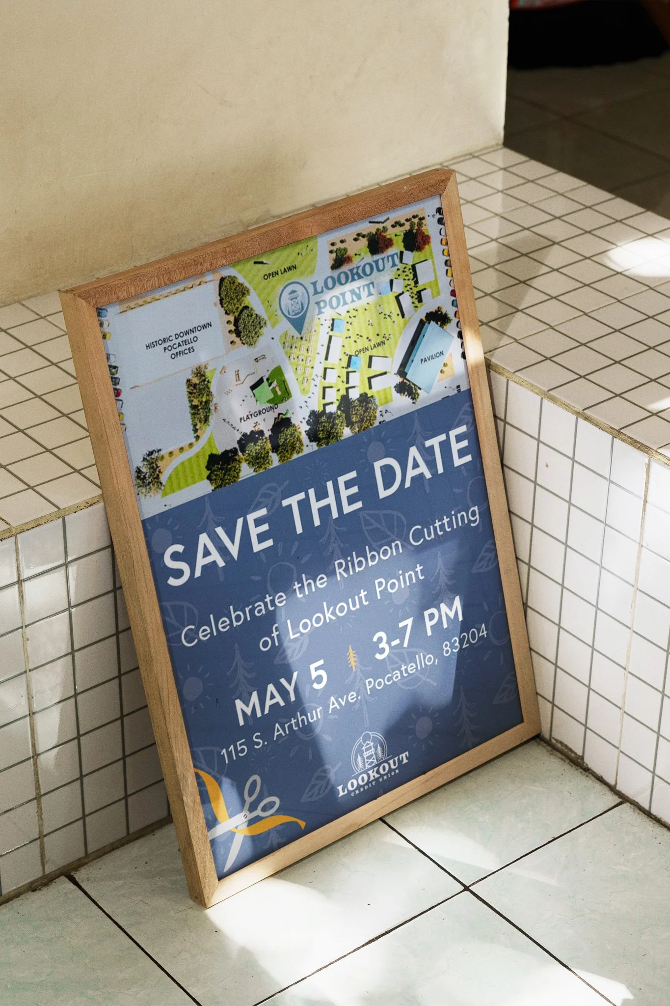 An indoor sign advertising a ribbon-cutting event for Lookout Point on May 5th, from 3 to 7 PM, at 115 S. Arthur Ave., Pocatello, Idaho. The sign features a map of the area.