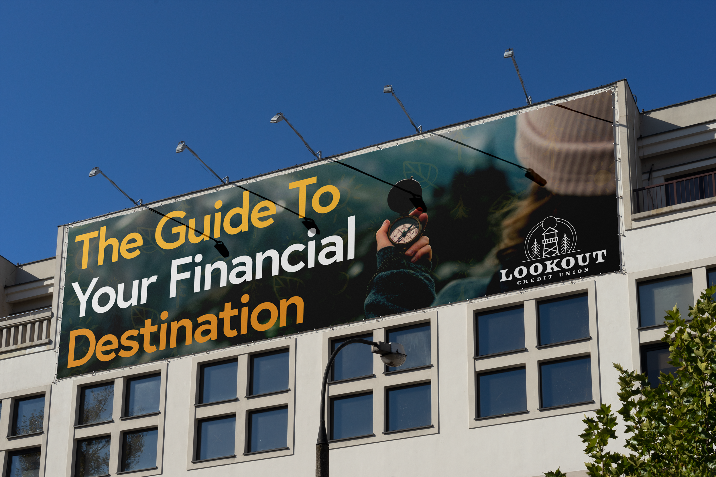 Billboard advertisement for Lookout Credit Union with the text 'The Guide To Your Financial Destination' and an image of a person holding a compass against a blue sky.