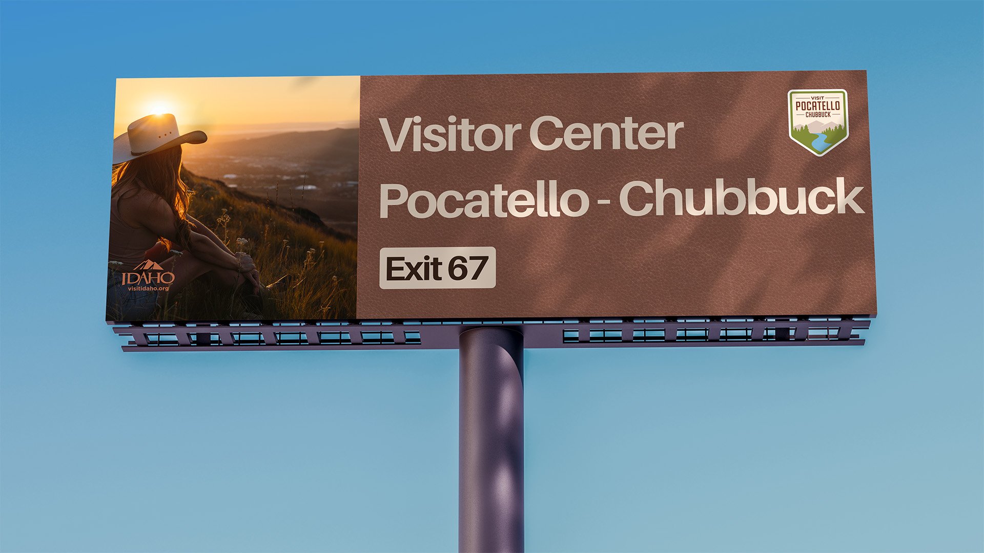 Billboard for Pocatello - Chubbuck Visitor Center, Exit 67, with a woman sitting on a hillside at sunset, wearing a cowboy hat, and the Idaho tourism logo.