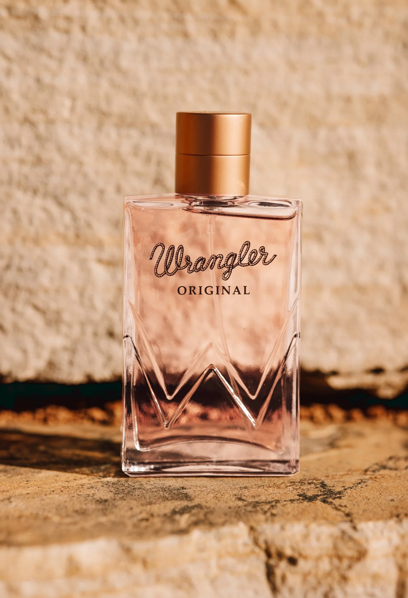Wrangler Original Women's fragrance bottle photographed in warm fall light against textured stone background for commercial campaign