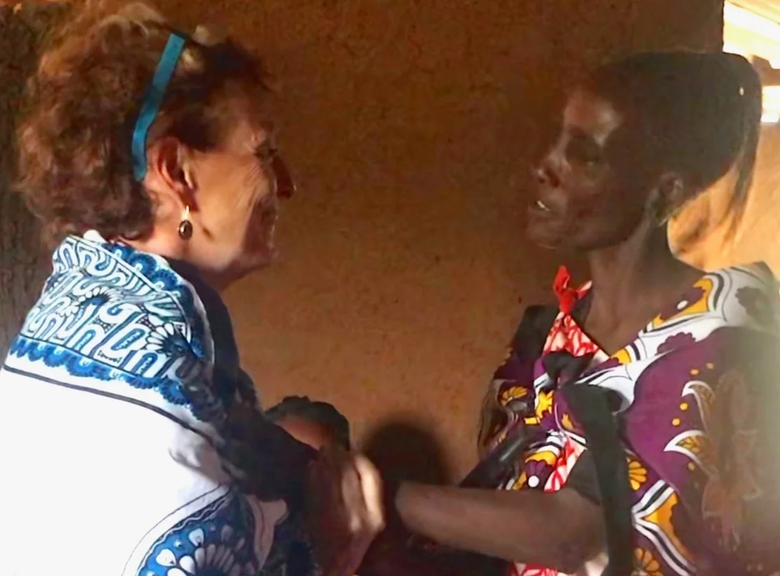 The mother of Mercy and Agnes presenting Kim with traditional Maasai gifts
