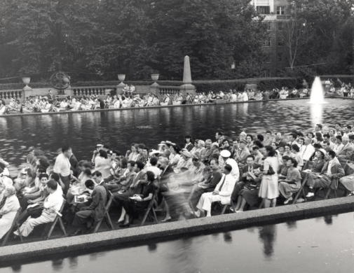  Audience at an event in the park,   via   