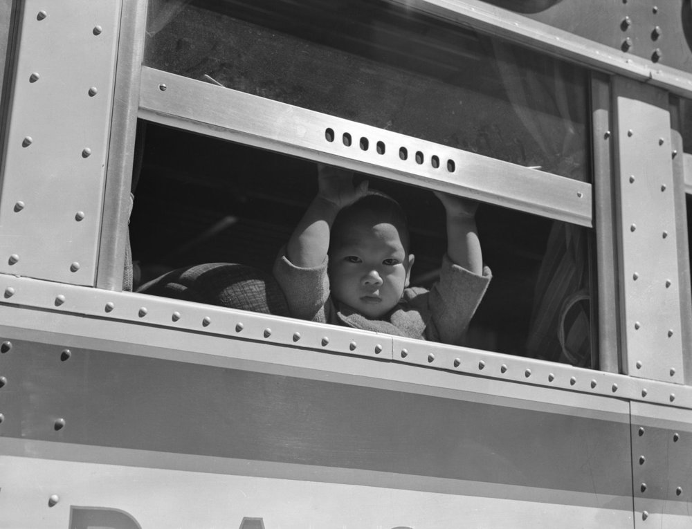 A child looks out the window of a bus bound for the Tanforan Assembly Center  via  