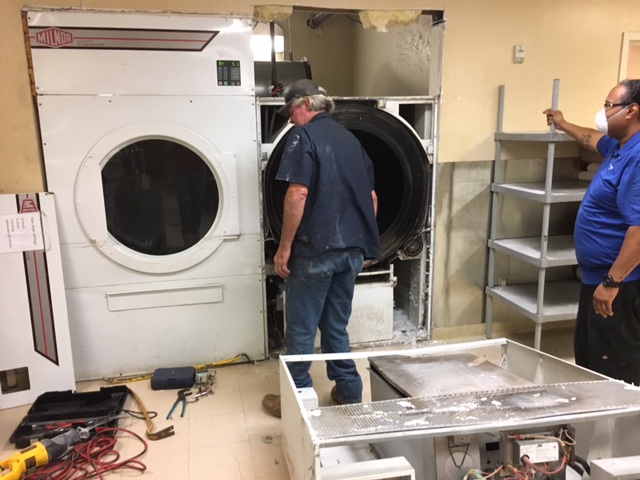 Old 120 lb. dryer on right coming out. This dryer comes in two pieces and the top control unit has already been removed and is on the floor in the bottom right of the pic.