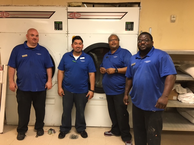 Here is Andre (second from right) and his engineering crew standing in front of their new Milnor 120 lb. dryer.