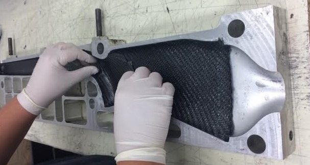 Laying pre-cut carbon fiber into the form.
