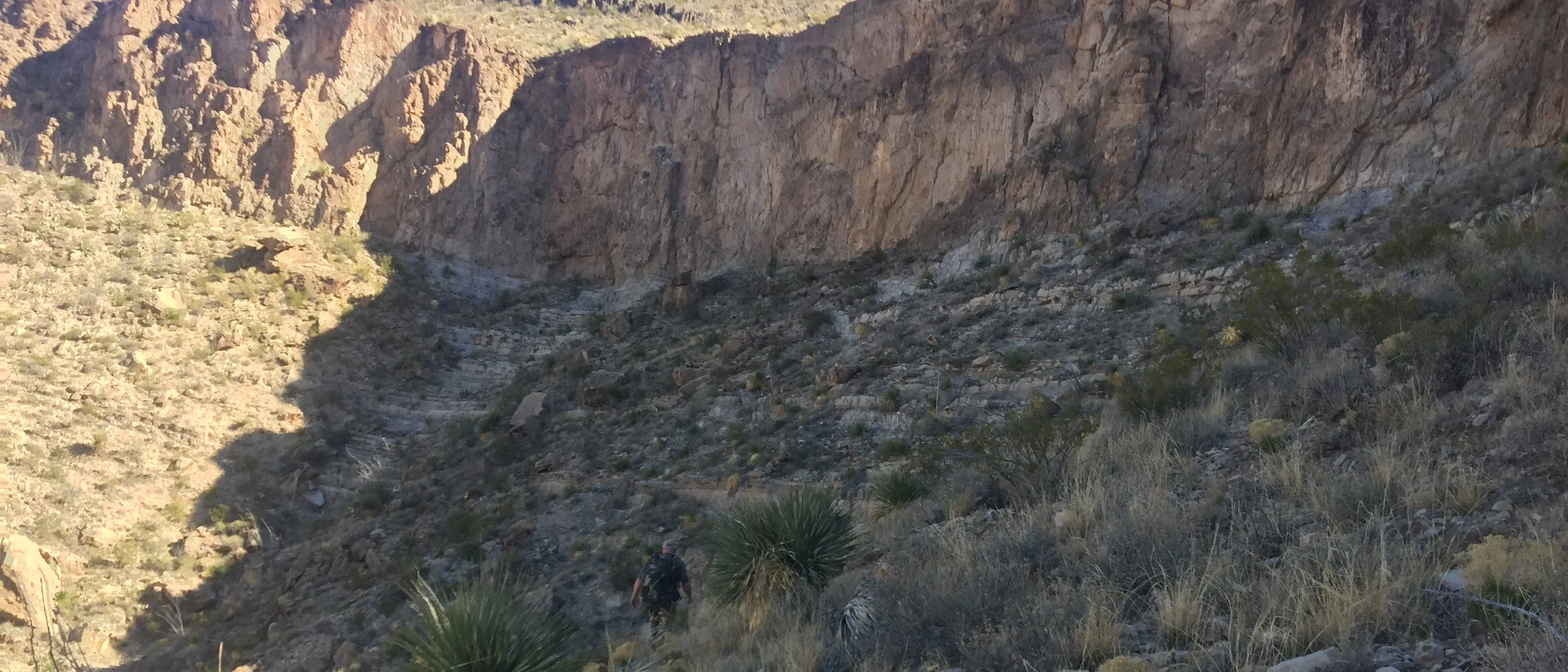 Cody crosses below one of many cliff bands, which appear deceivingly small from miles away.