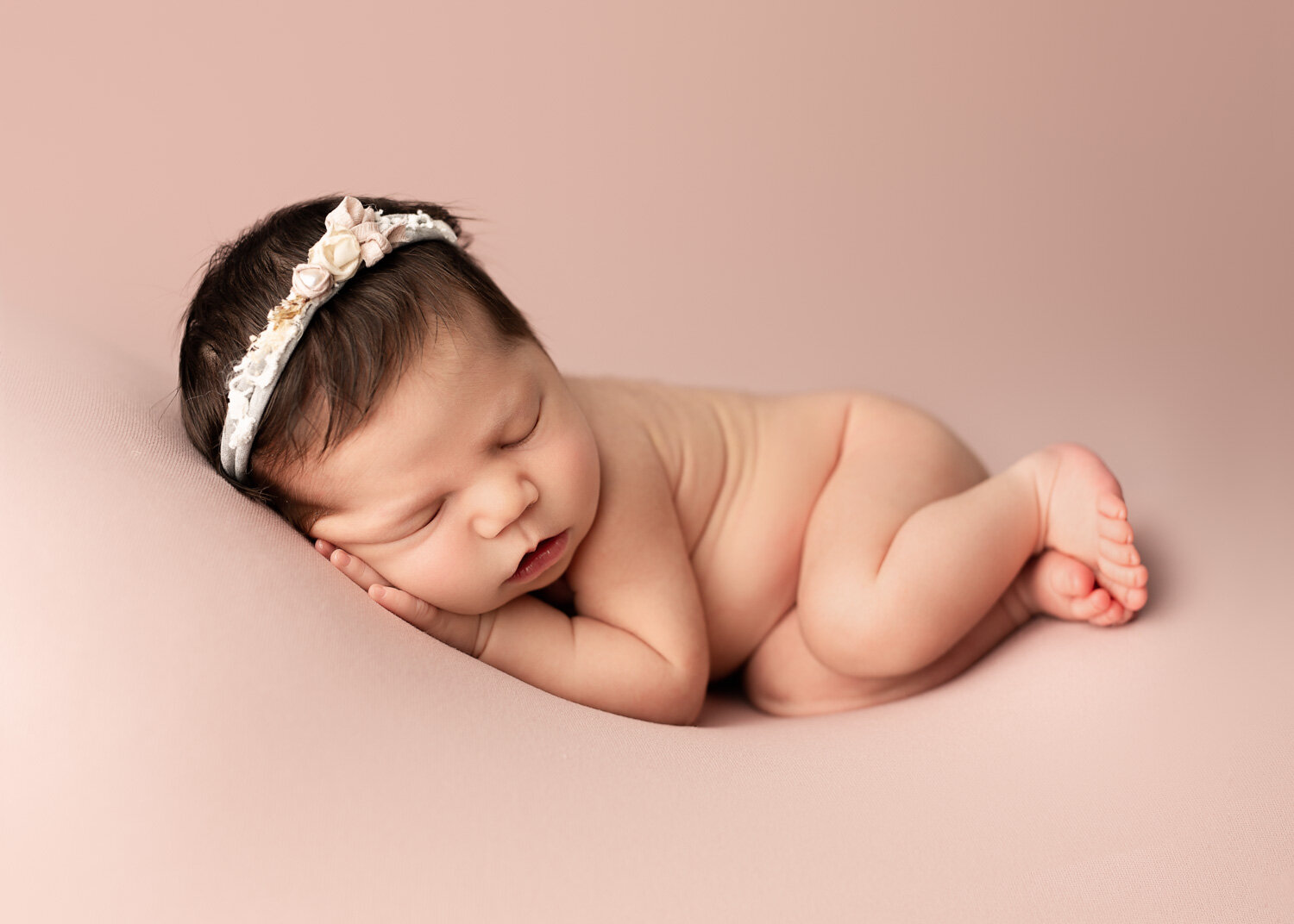 Newborn baby girl lying on side on blush pink blanket with Sue Skrabek photography in winnipeg 
