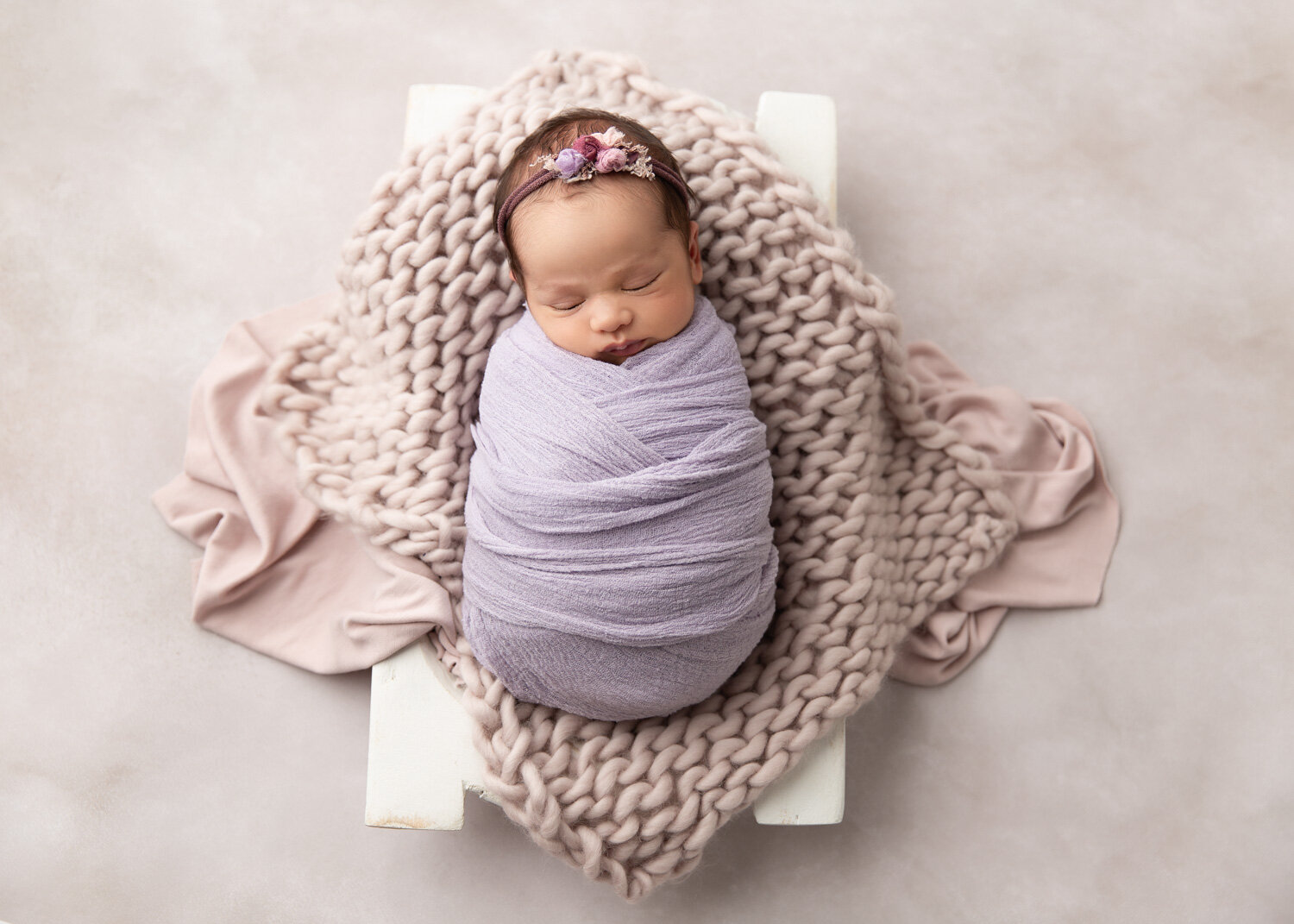  Soft mauve and blush pink prop set up for newborn baby girl during photosession in Winnipeg 