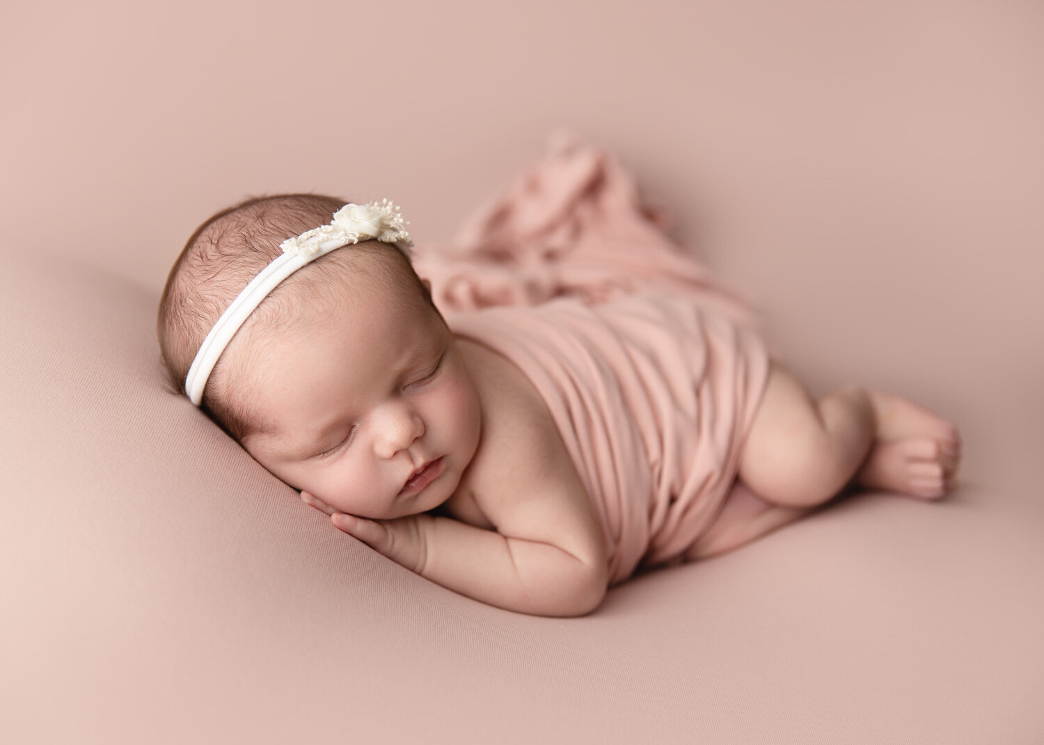  Sue Skrabek Photography newborn session in Winnipeg with girl lying on side with beautiful blush pink wrap i 