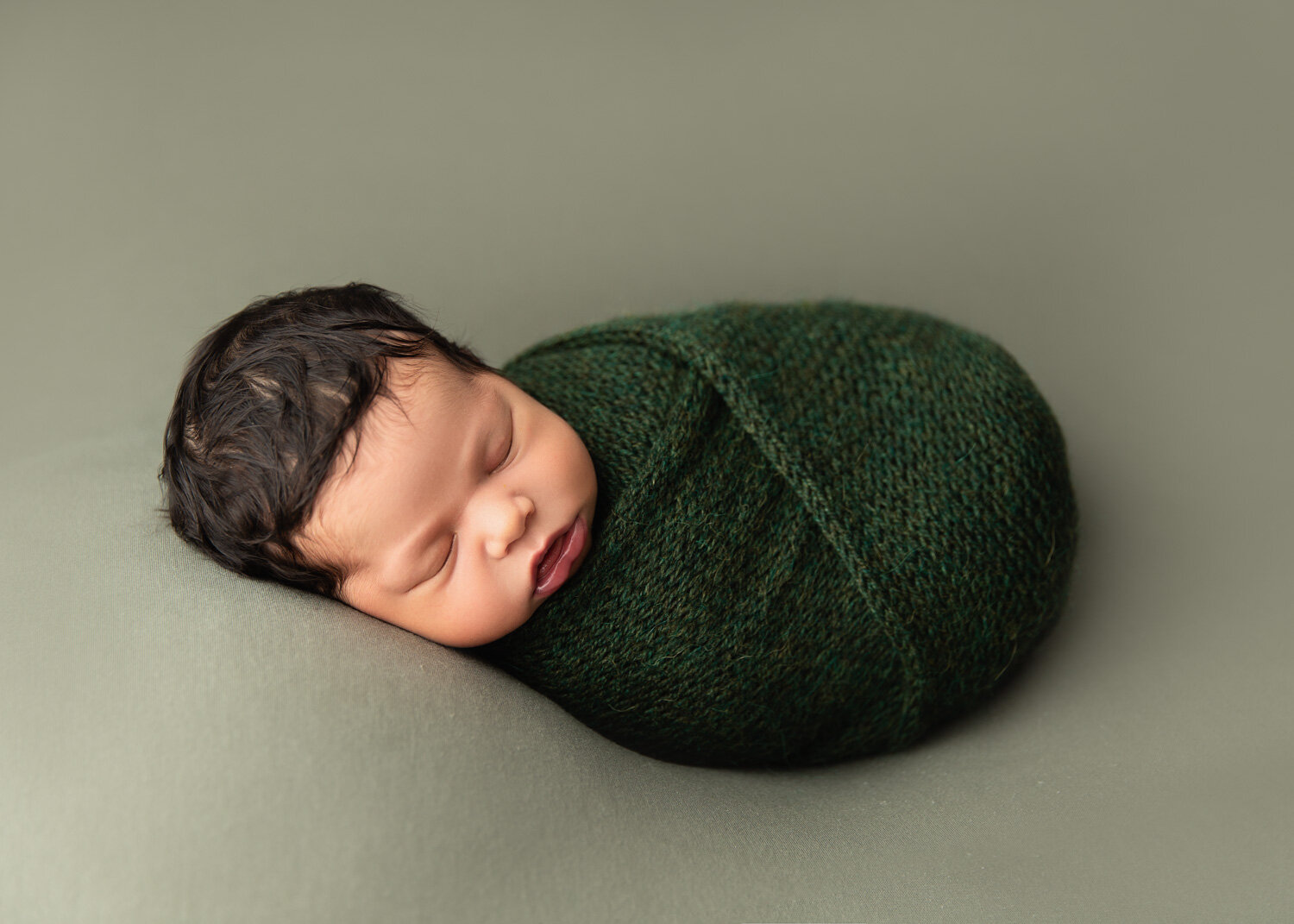 Soft earthy green toned wrapped up baby newborn boy on blanket during photosession in Winnipeg with Sue Skrabek Photography 
