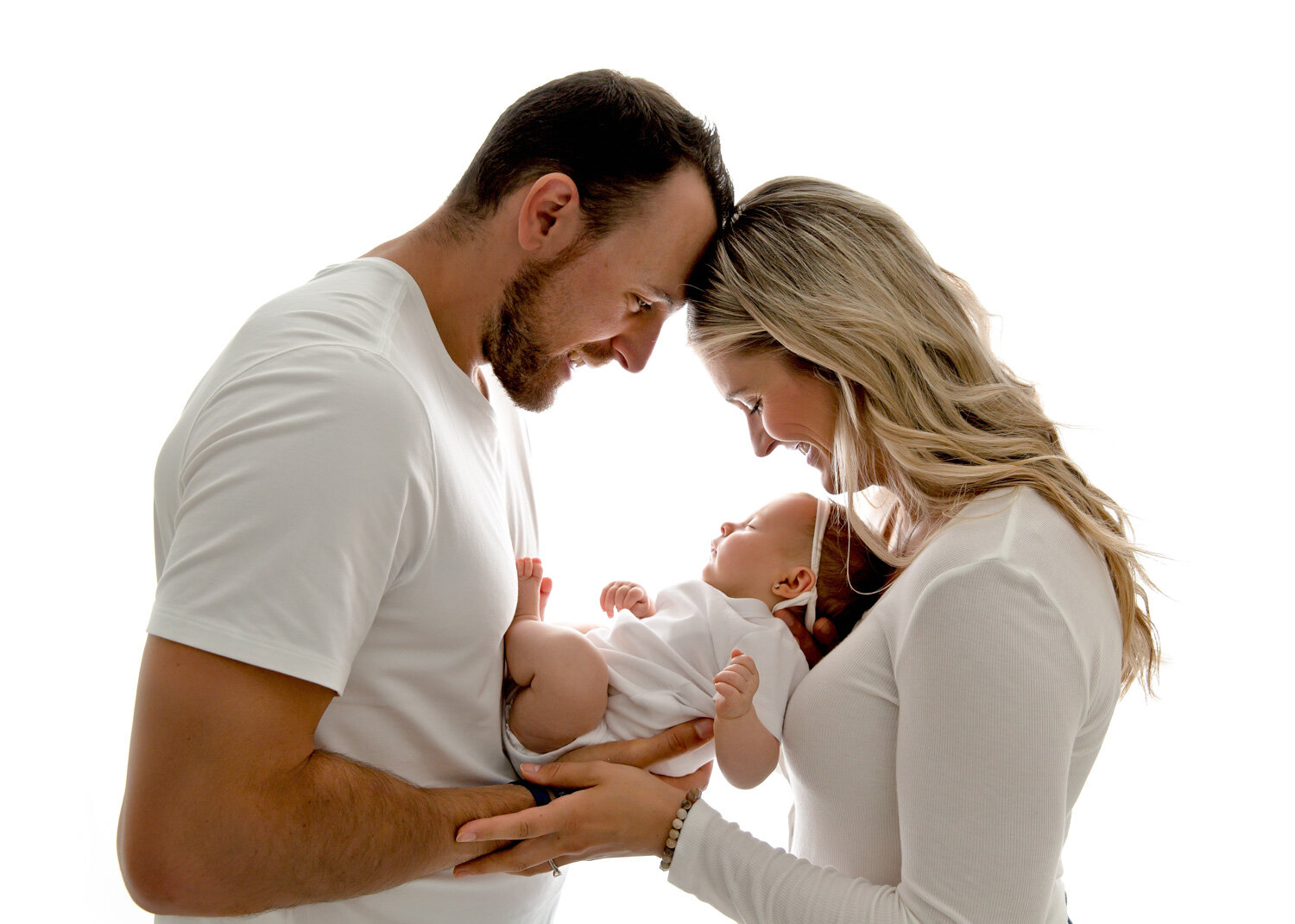  Backlit setup parents holding newborn with Sue Skrabek Photography dressed in white baby session in Winnipeg 