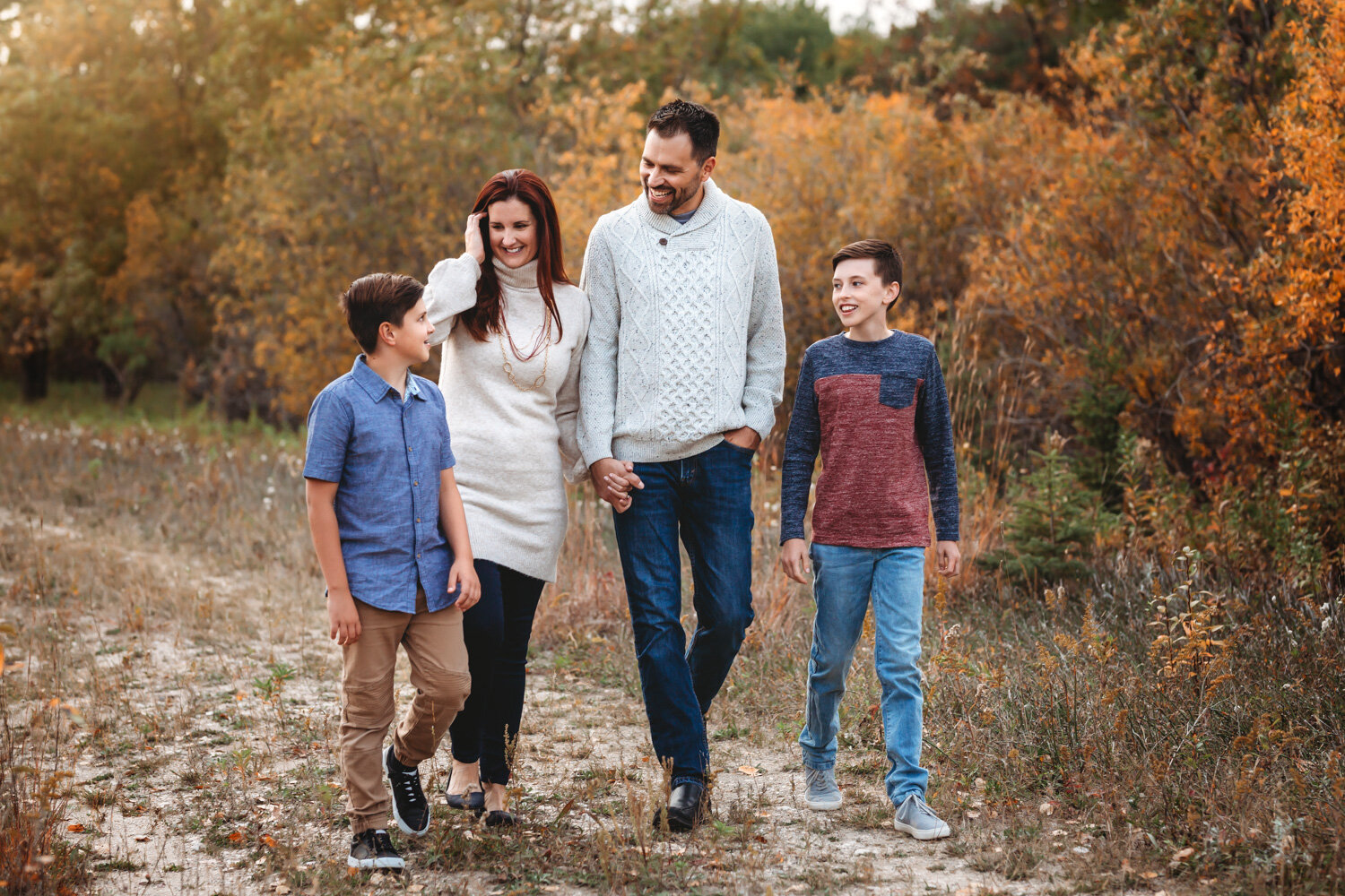  Family of four with teen boys walking in fall colors at Birds Hill park near Winnipeg 