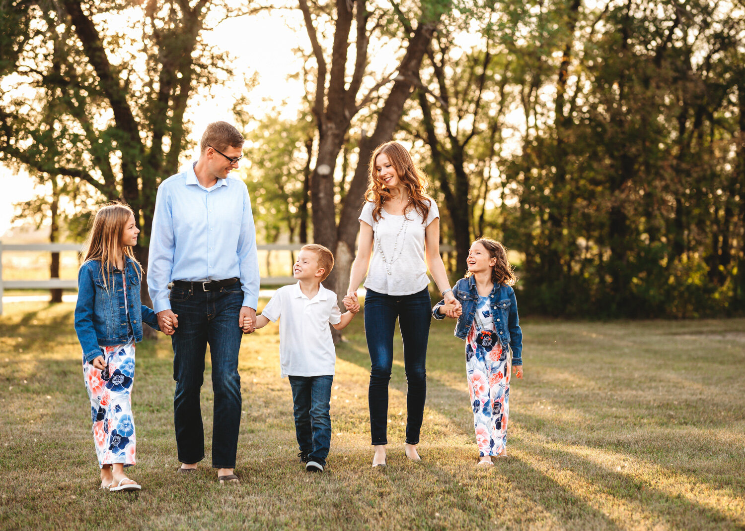  Family of five holding hands walking laughing summer photoshoot St. Norbert Ruins near WInnipeg 