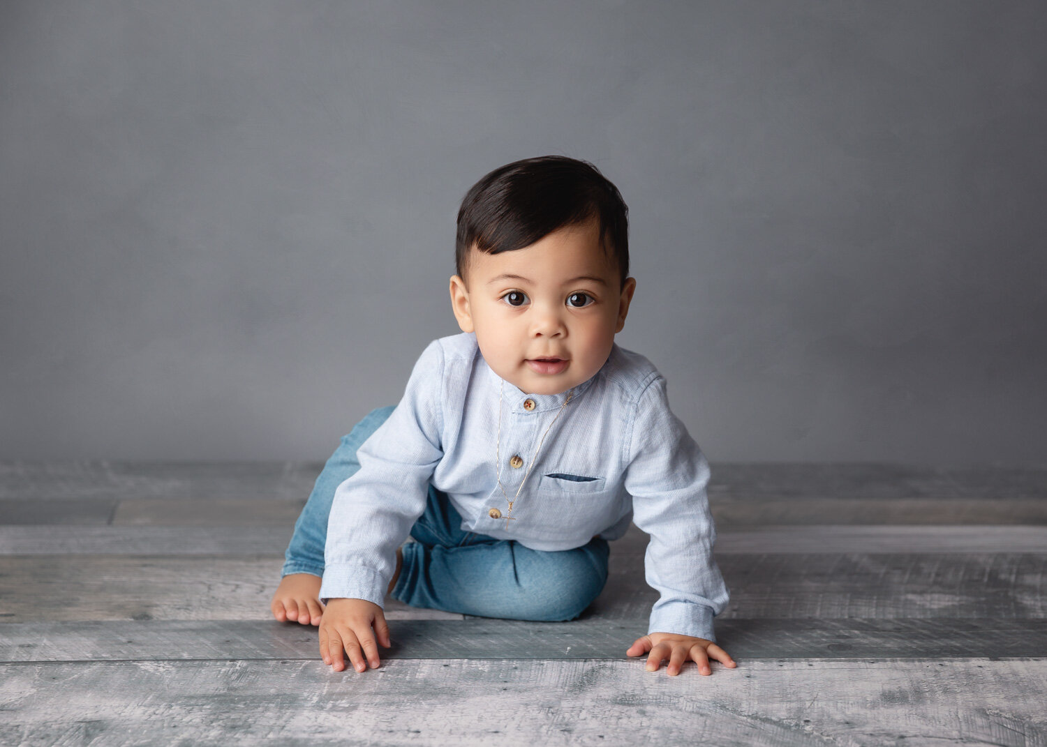  Hansome boy in pale blue dress shirt sitting for child milestone session in Winnipeg studio 