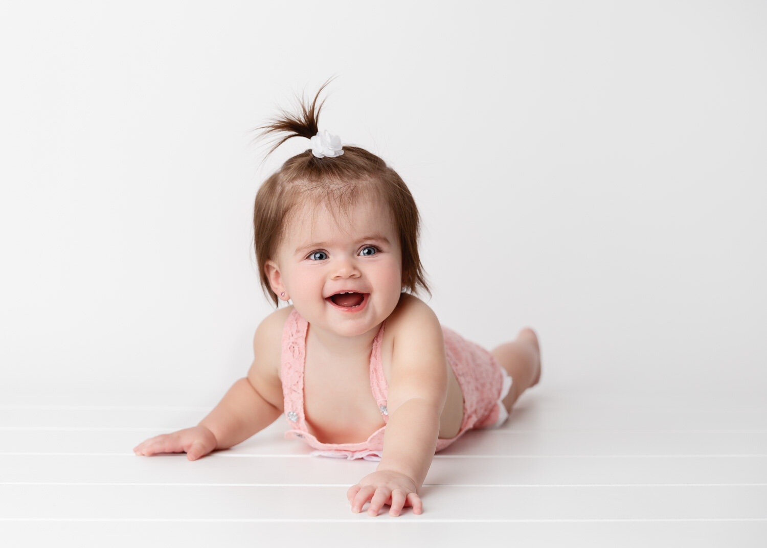  Happy baby girl with top ponytail on tummy for child photoshoot in Winnipeg 