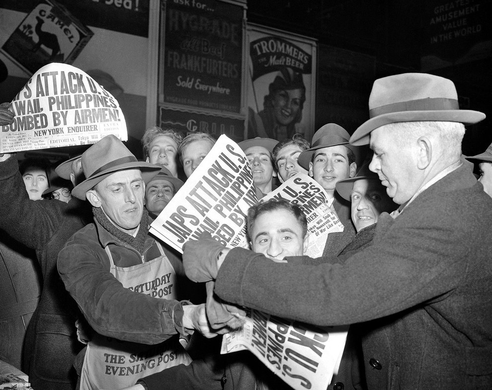 In the streets, people buy newspapers reporting the Japanese attack on U.S. bases in the Pacific Ocean..jpg
