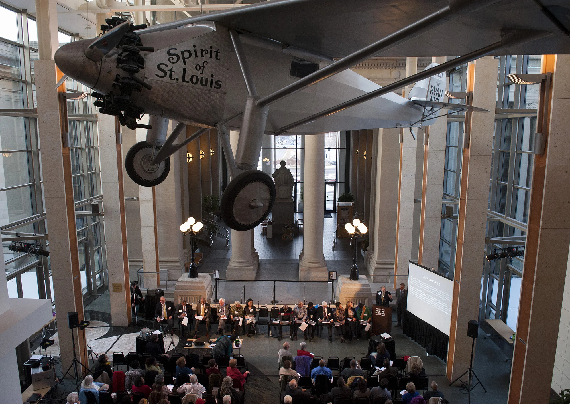Members of the Ferguson Commission appointed by Missouri Gov. Jay Nixon gather beneath the reproduction of Charles Lindbergh's "Spirit of St. Louis" at the Missouri History Museum in Forest Park in St. Louis for their meeting Monday, March 2, 2015. …