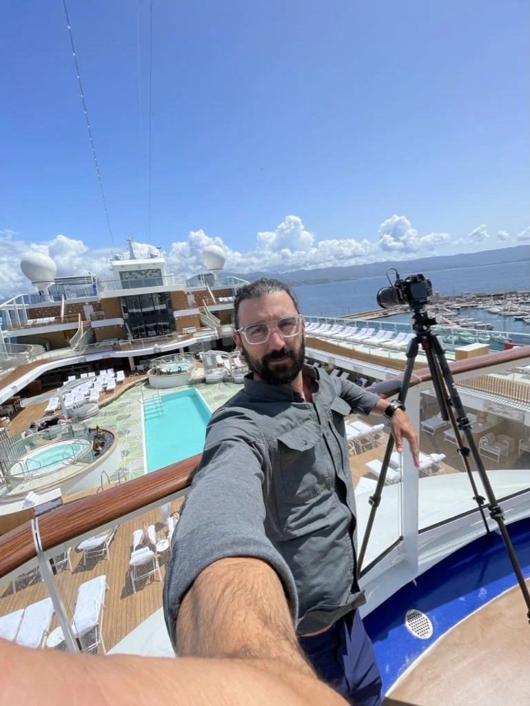 Hotel photographer taking selfie on cruise ship deck during photoshoot in Greece
